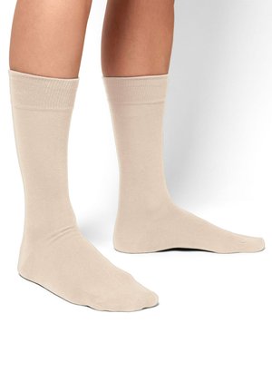 Beige katoenen sokken met een gladde textuur, halverwege de kuit lengte, en geribbelde boorden. Eenvoudig ontwerp zonder patronen of accenten.