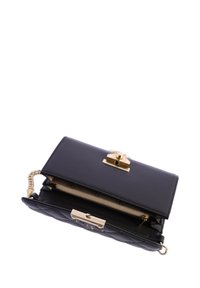 Bolso de piel negra con una correa de cadena, herrajes dorados, textura acolchada y cierre de clasp. El interior cuenta con un forro estampado.