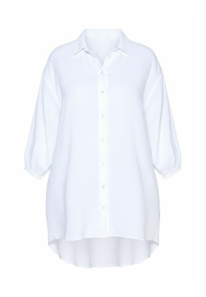 Camisa blanca extragrande abotonada con tela texturizada, que presenta un cuello clásico, mangas abullonadas y un dobladillo asimétrico alto-bajo.