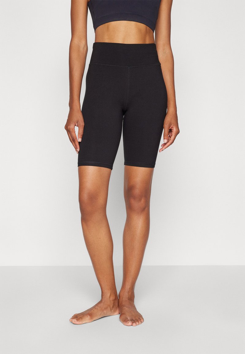 Sorte cykelshorts lavet af strækbart stof med en glat tekstur. Høj talje og tætsiddende design. Kanten når til midt på låret.