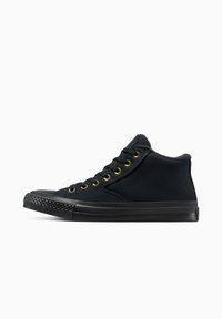 Zwarte high-top sneakers van canvas, met gouden veterogen, een gestructureerde zwarte rubberen neuskap en een gladde zwarte zool.
