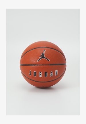 Palla da basket arancione con superficie testurizzata, caratterizzata da un logo Jumpman nero e testo 'JORDAN'. Progettata per il gioco indoor/outdoor.