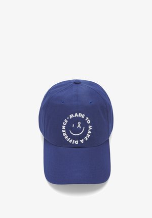 Blauwe honkbalpet met een gebogen klep. Bevat witte geborduurde tekst met de woorden "MADE TO MAKE A DIFFERENCE" rondom een smiley-ontwerp.