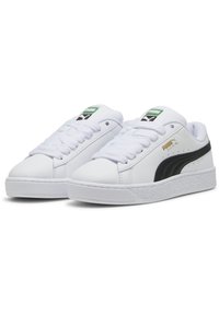 Feh�ér bőr sneaker cipők fekete oldalsávval és arany logóval, fehér fűzővel, texturált gumitalppal és párnázott boka támogatással.