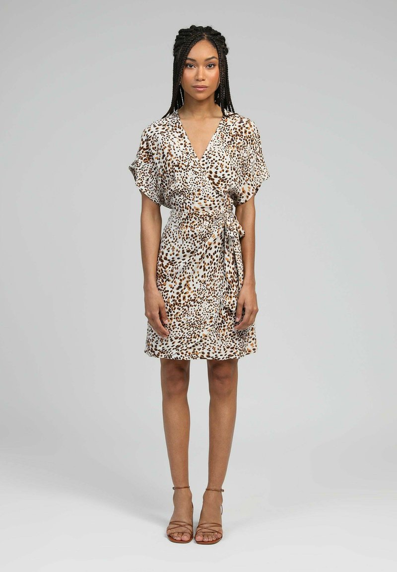 Robe portefeuille à imprimé léopard en tissu léger, avec des manches courtes, une taille ceinturée et un ourlet évasé. Couleurs beige et marron.