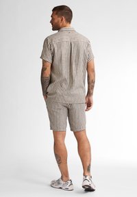 Korte mouwen, overhemd met kraag en korte broek set, met een beige en bruine gestreepte patroon, met een relaxte pasvorm en casual stijl.