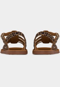 Ζευγάρι ίσιων σανδαλιών με λουριά σε λεοπάρ σχέδιο και καφέ σόλες, απεικονισμένο από πίσω πάνω σε απλό λευκό φόντο.