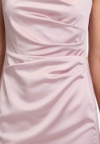 Abito di raso rosa con un design elegante caratterizzato da dettagli arricciati e una texture morbida, che mette in risalto pieghe eleganti e una silhouette aderente.
