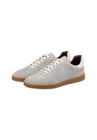 Un par de zapatillas de ante gris claro con cordones blancos, suelas de goma, paneles del talón blancos y la marca "JOOP!" en el costado.