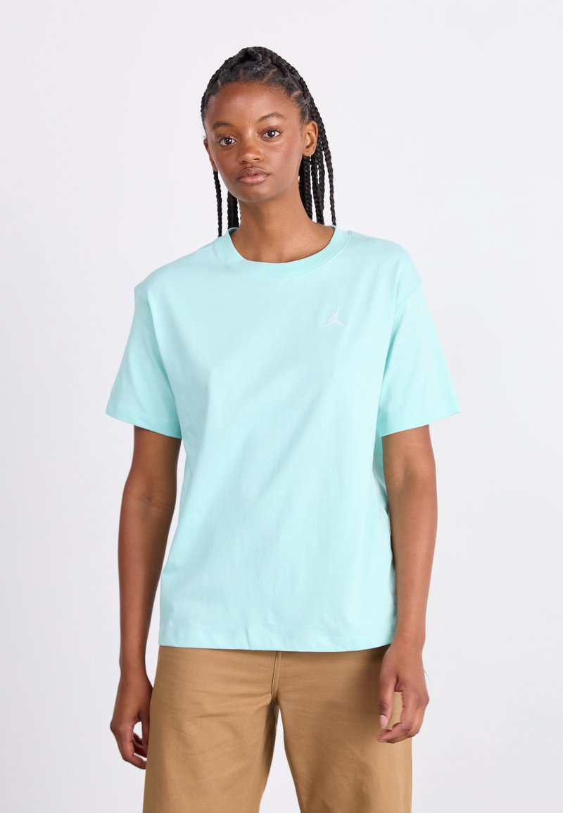 Mintgrøn bomulds T-shirt med korte ærmer og rund hals, med et lille hvidt logo på brystet. Bæres med khaki bukser.