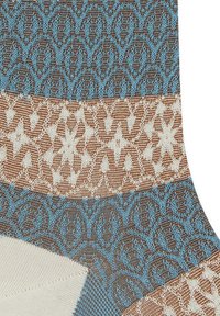 Il tessuto presenta motivi geometrici nei toni di marrone, crema e blu. Il design include motivi alternati con tessuti texture.
