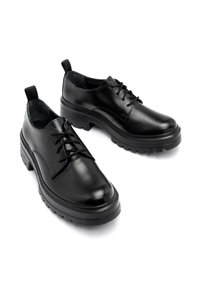 Scarpe in pelle nera con una finitura liscia, design con lacci, suola in gomma spessa e grip robusto, con linguette sul tallone.