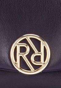 Round purple leather bag featuring a prominent gold emblem with the letters "R" and "D" intertwined in a geometric design.