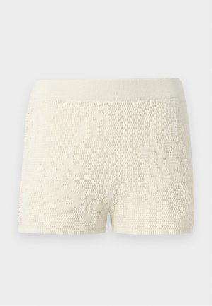 Strickshorts in Off-White mit einem strukturierten Muster. Verfügt über einen breiten elastischen Bund und ein figurbetontes Design.
