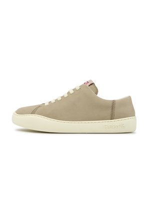 Beige lage sneaker met witte zool, witte veters en subtiele stiksels. Camper-logo geperst aan de buitenkant vlakbij de hiel.