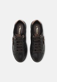 Zapatillas negras con un acabado de cuero suave, detalles en acento marrón, cordones planos y una plantilla acolchada. Talla 37 indicada en el interior.