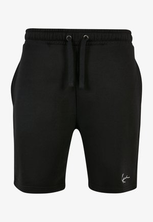 T-shirt blanche à manches courtes avec des rayures verticales noires et un logo rouge ; associé à un short noir et des baskets blanches avec des accents noirs.