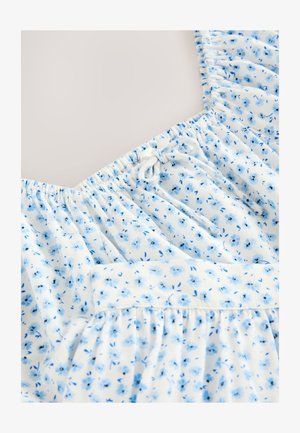 Virágos ruha, fehér alapon kék virágmintával, összegyűrt nyakkivágással, állítható kötőfűzőkkel és texturált, bővülő szoknyarésszel.