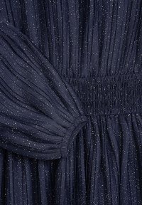 Marineblaues plissiertes Kleid mit geraffter Taille und Puffärmeln, verziert mit dezenten metallischen Sprenkeln für zusätzliche Textur.