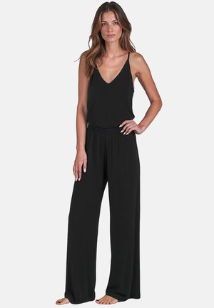 Sort jumpsuit med en tætsiddende overdel og brede ben. Tynde stropper og V-udskæring. Fremstillet af blødt, let materiale.