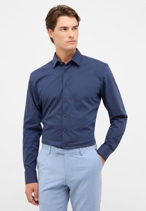 Marineblauwe overhemd met lange mouwen, knopen en een klassieke kraag, met een gladde, textuurstof. Gemaakte combinatie met lichtblauwe broek.