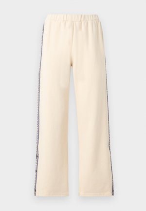 Kermanväriset leveälahkeiset housut, joissa on joustava vyötärö ja koristeelliset kuvioidut sivuraidat sinisenä ja mustana.