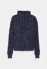 Mörkblå fleecejacka med hög krage, dragsnören och en präglad mönster. Har ribbade ärmslut och nederkant, mjukt material.