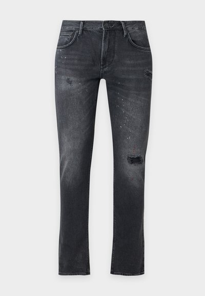 Μαύρο στενό τζιν με φθαρμένες τρύπες και λευκές πιτσιλιές βαφής, διαθέτει μπροστινές και πίσω τσέπες και θηλιές για ζώνη.