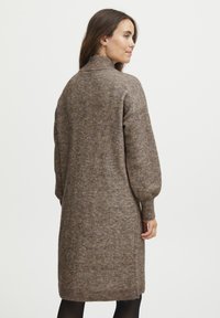 Robe en mélange de laine marron avec un col haut, des manches longues et des poignets côtelés, présentant une coupe décontractée et une longueur midi.