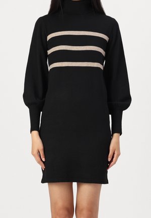 Černé pletené šaty s vysokým límcem a dlouhými nařasenými rukávy. Na hrudi jsou horizontální béžové pruhy. Hladká textura, přiléhavý střih.