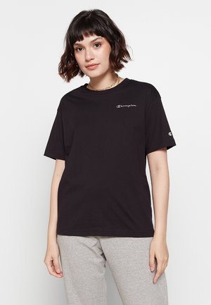 T-shirt in cotone nero con maniche corte, scollo rotondo e logo "Champion" ricamato sul petto. Design semplice, vestibilità comoda.