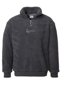 Fleece-pullover i mørkegrå med høy krage, kvart glidelås, ribbestrikkede mansjetter og brodert logo på brystet. Myk, textured stoff.