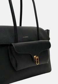 Borsa a tracolla nera in pelle con texture a granuli, chiusura a patta, dettagli in metallo dorato e lunghe maniglie in pelle. Nome del marchio impresso sul davanti.