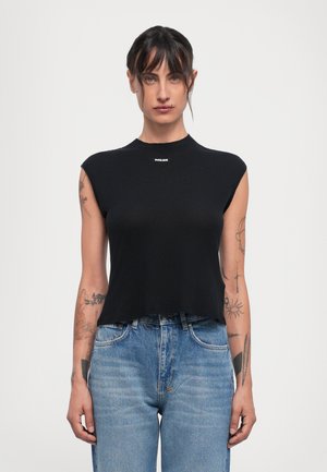 Black, sleeveless crop top made of ribbed fabric with a high neck. Features a small branded logo on the front. Paired with blue jeans.