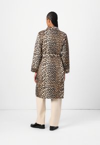 Leopardenmuster-Robe mit tailliertem Bund, langen Ärmeln und Kragen. Es hat eine weiche Textur und einen kräftigen Farbkontrast aus Braun, Schwarz und Creme.