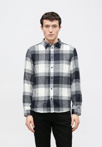 Koszula flanelowa z długim rękawem, z wzorem w kratę w kolorach granatowym, białym i szarym, z kołnierzykiem na guziki i czarnymi guzikami z przodu.