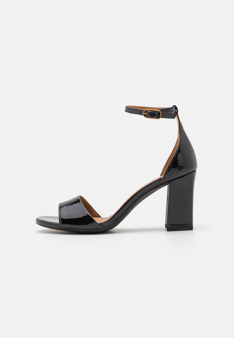 Schwarze High-Heelsandale mit glänzender Lackoberfläche, offener Zehenpartie, Knöchelriemen mit goldenem Schnallenverschluss und Blockabsatzdesign.