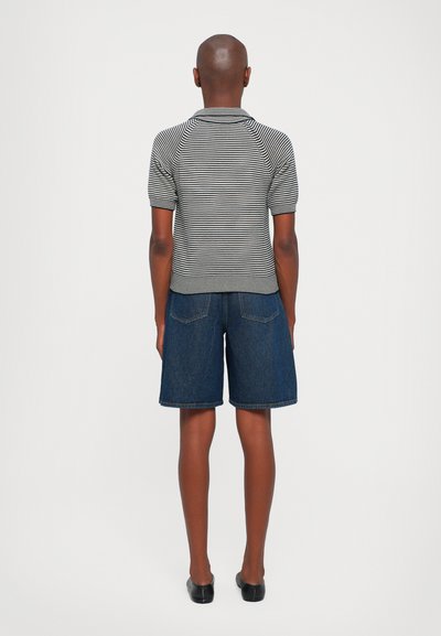 Striped knit polo shirt paired with blue denim shorts. The shirt features short sleeves and a collar, while the shorts have a relaxed fit and pockets.