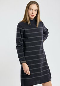 Robe en tricot navy avec des rayures horizontales grises, présentant des manches longues et des poignets à carreaux. Texture douce et coupe décontractée.