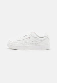 Sneaker bianca con tomaia in pelle liscia, dettagli perforati, chiusura con lacci e una suola bianca spessa e imbottita. Presenta un logo discreto.