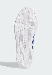 Bijela potplate tenisica s teksturiranim gumiranim uzorkom, koja sadrži tri plave pruge i utisnuti "adidas" logo sa strane.