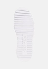 Talpa de pantof din cauciuc alb, cu striații orizontale pentru aderență, având logo-ul embosat "GUESS" în centru și un design cu vârful rotunjit.