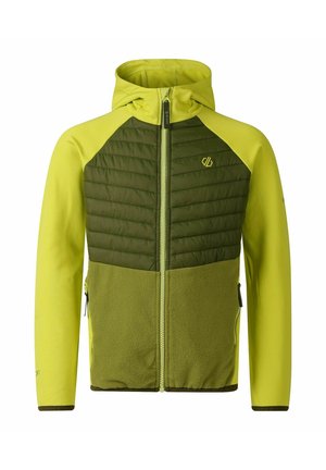 Junge mit lockigem Haar, der eine grün-gelbe Zip-Up-Jacke trägt und eine grüne Wasserflasche vor einem einfarbigen Hintergrund hält.