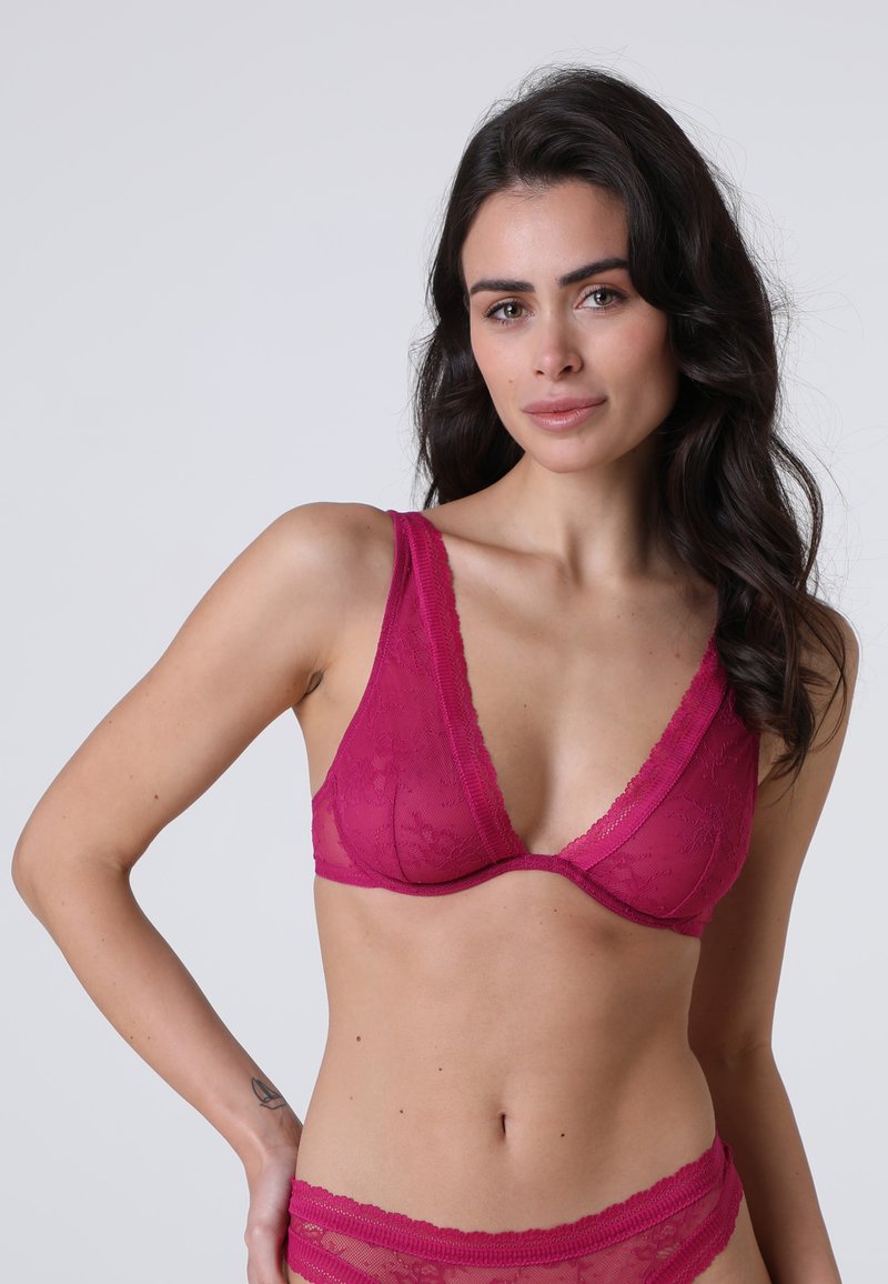 Reggiseno con pizzo a contrasto, scollatura a V profonda in fucsia acceso, realizzato in tessuto morbido e con supporto con ferretto, caratterizzato da spalline larghe e un motivo decorativo.