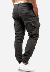 Katoenen cargo broek in donkergrijs met elastische boorden, meerdere zakken en een Calvin Klein merkband. Heeft een slim fit ontwerp.