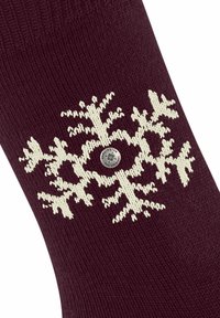 Burgundowe skarpetki dziane z białym wzorem śnieżynki i okrągłym srebrnym logo na środku. Miękka tekstura w standardowym kształcie skarpety.