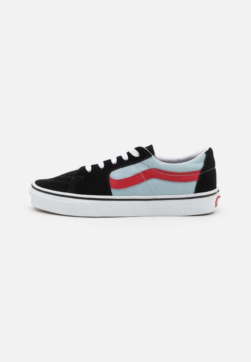 Svart og lyseblå sneaker med rød sidestrek, hvite snøringer og gummisåle. Suede og tekstilmaterialer med kontrasterende teksturer.