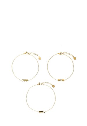 Trois bracelets en or avec des designs de chaîne délicats et des accents en forme de cœur. Chacun possède un fermoir à homard et une longueur ajustable.