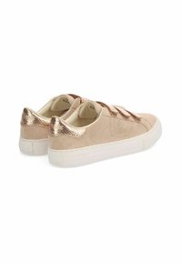 Sneaker beige in suede con accenti metallici bronzo, design senza lacci e retro testurizzato, dotati di una spessa suola bianca per il comfort.