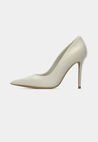 Escarpin blanc à bout pointu avec une finition lisse et élégante. Talon stiletto et design minimaliste avec une semelle couleur nude. Texture douce sur toute la chaussure.